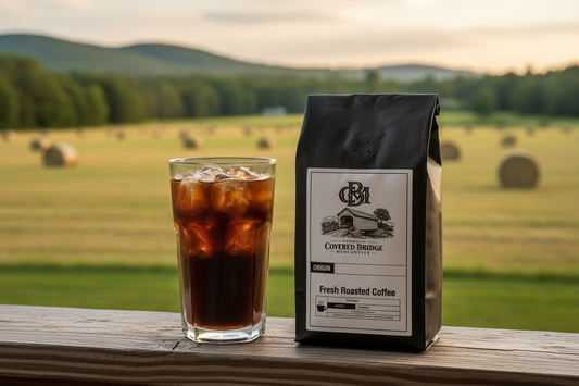 Coffee bag standing beside iced coffee in clear glass