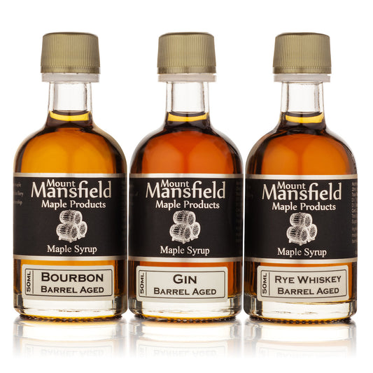 Three Mount Mansfield maple syrup bottles: bourbon, gin, and rye barrel aged