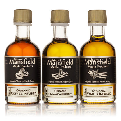 Three Mount Mansfield maple syrup bottles, gold caps, organic coffee, cinnamon, and vanilla infused