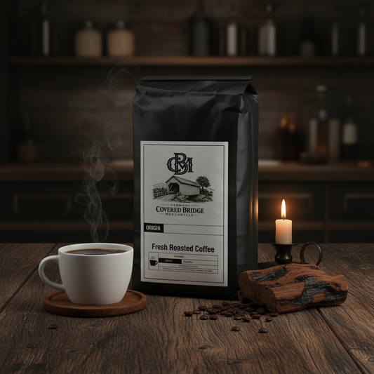 Coffee bag with front label, with white mug and candle on wooden surface.